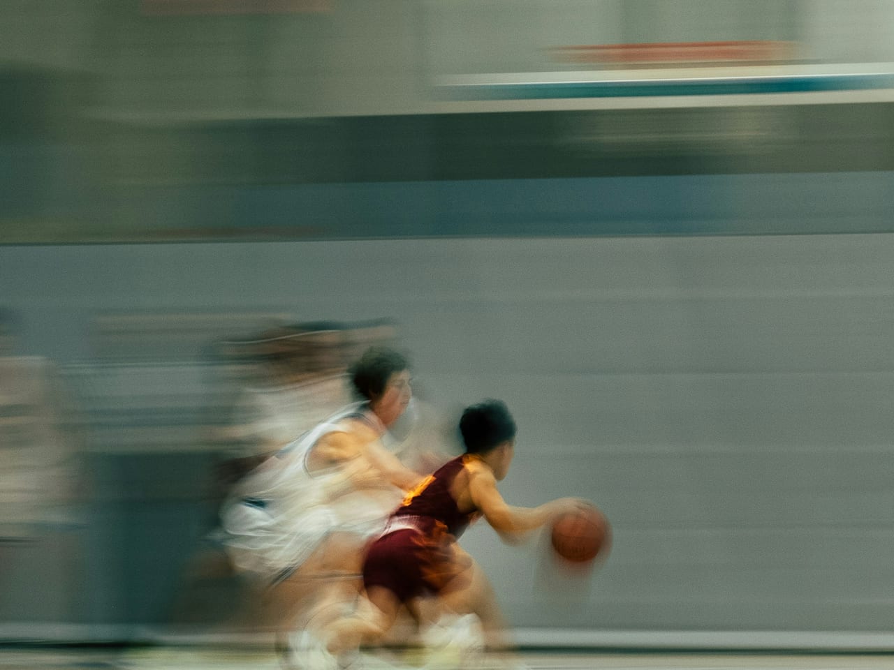 Basketball players in motion beneath the hoop