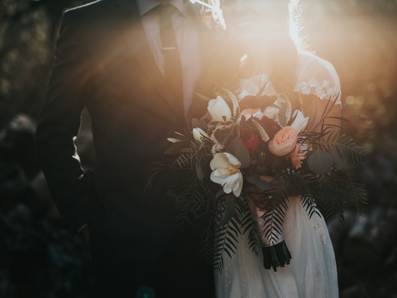 Bride and groom standing together with the bride holding a bouquet